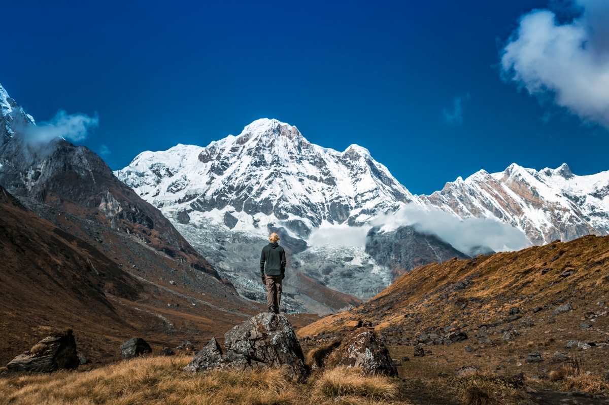 Photo of a man looking in awe at Annapurna mountain range near Annapurna Basecamp in Nepal