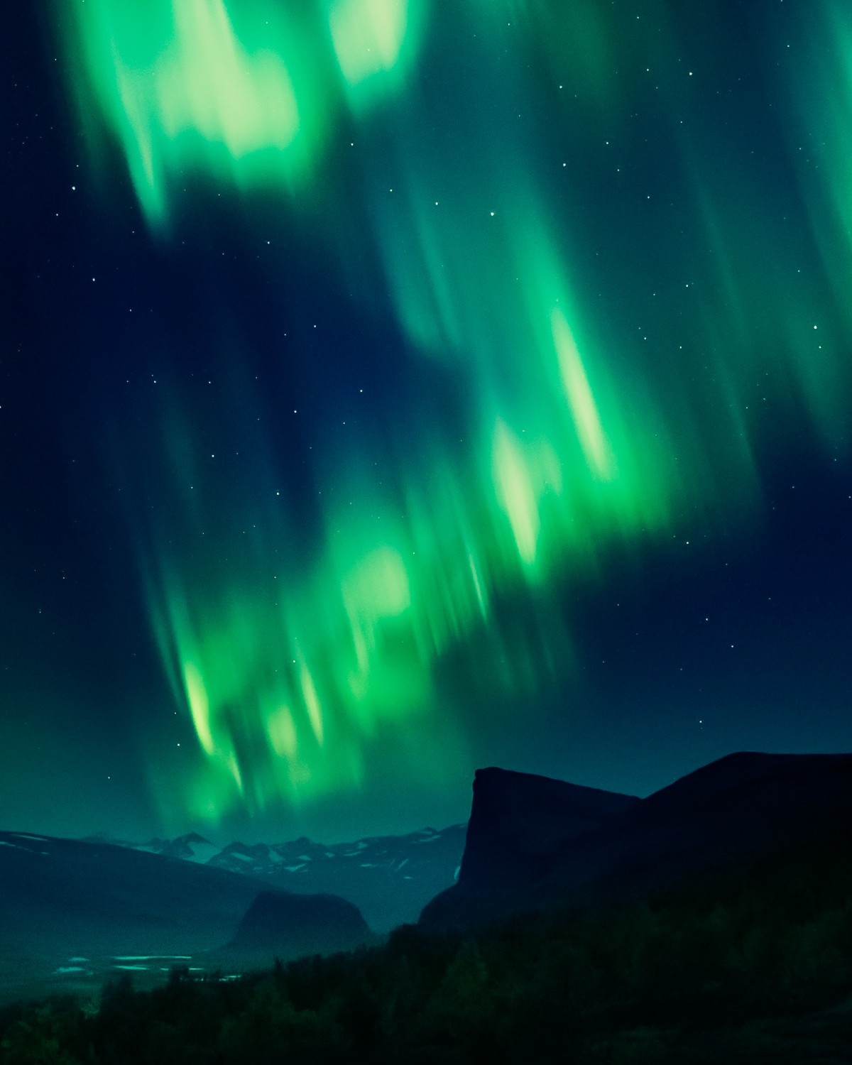 Photo of northern lights over starlit landscape